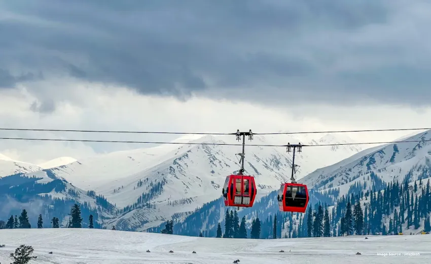 red cable cars on gulmarg gondola ropeway during winters with snow capped peaks