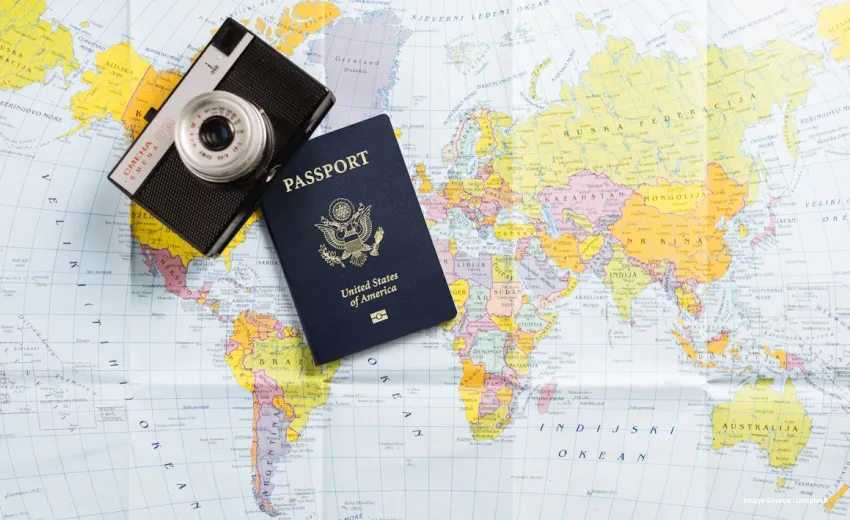 a world map lying with passport and a camera on top