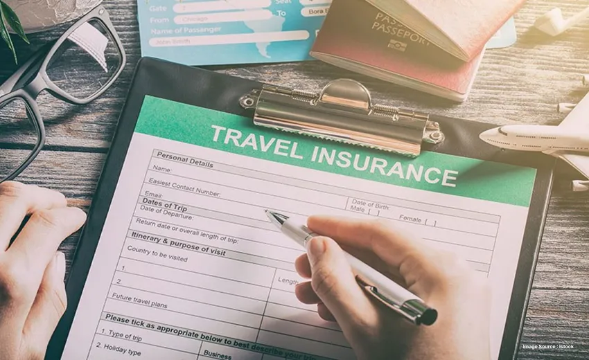 capture of a person filling up a travel insurance form as their glasses lie besides