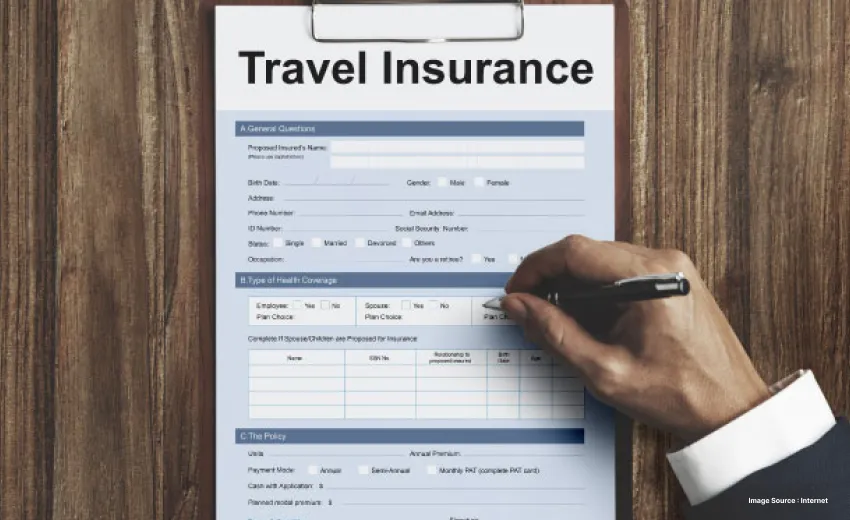 a person filling a travel insurance form clipped to a hard board