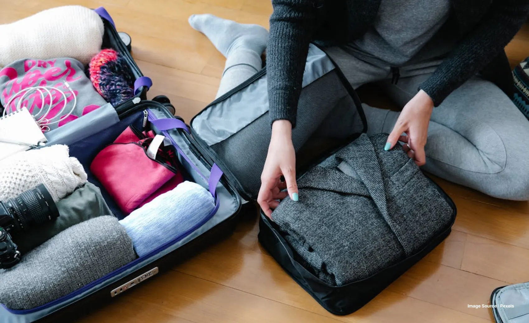 a white woman rolling clothes into a carry bag for traveling