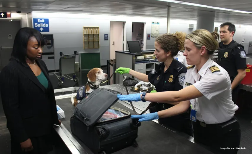 A tourist with a pet being stopped at a TSA checkpoint