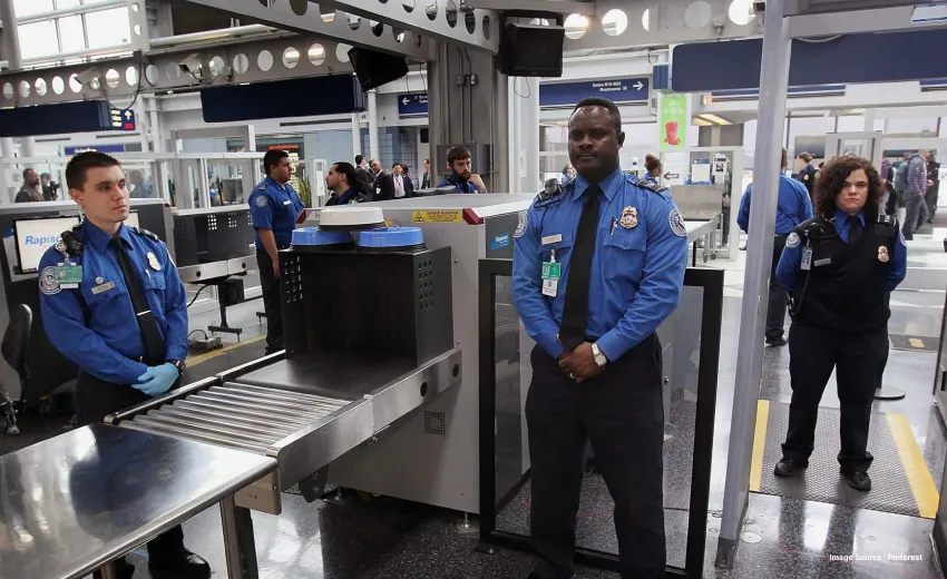 airport security area with xray machine for luggage and walk through detectors as uniformed security personnels surround it