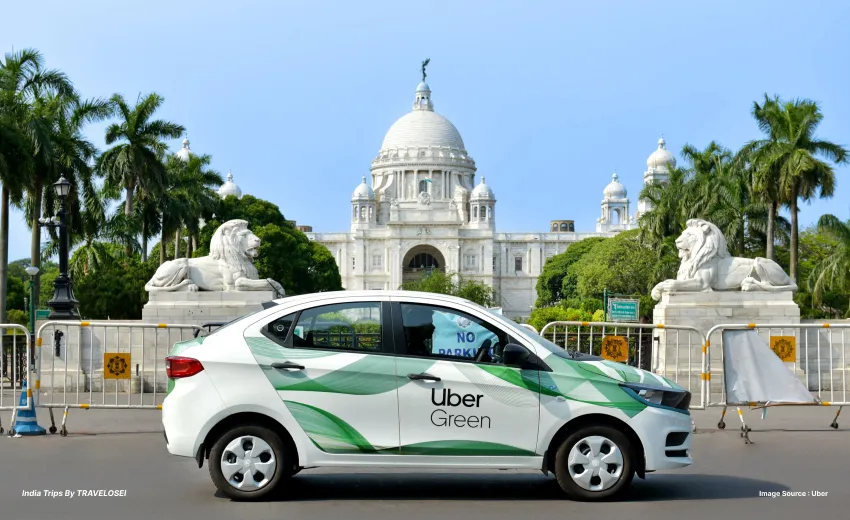 An Image of an uber green taxicab going through a road in India