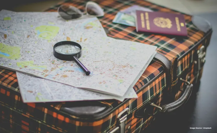 a map laying on the table with magnifying glasses and other travel docs