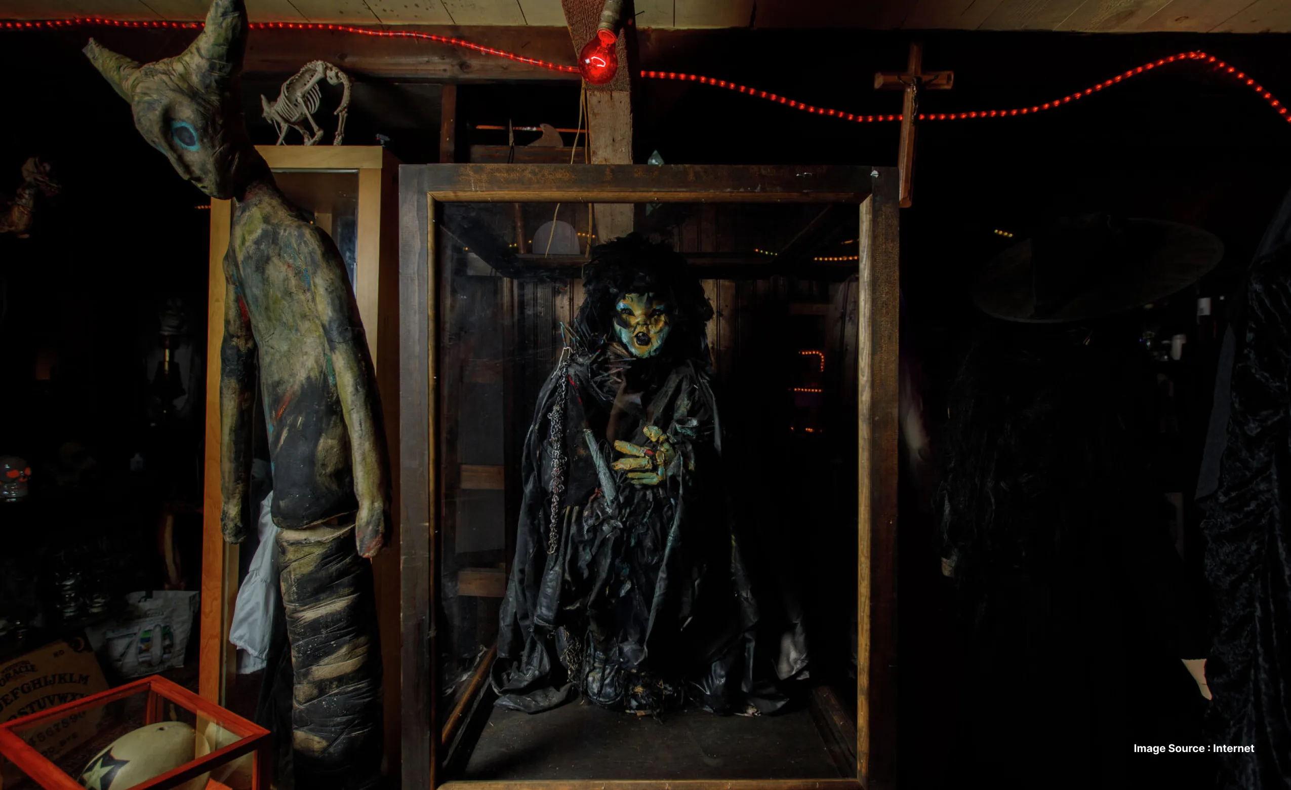a mummified doll in a glass case besides other creepy items at the ed and lorraine warren museum