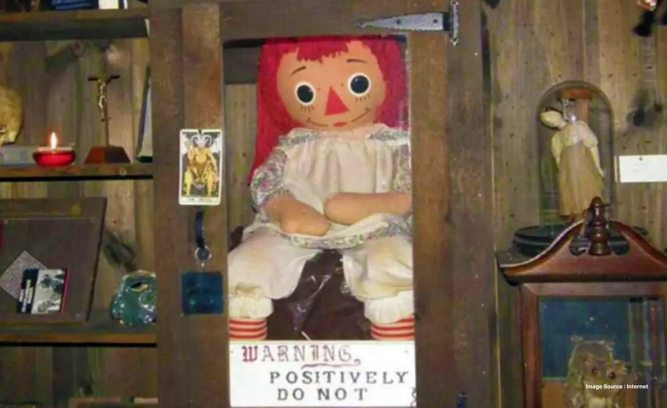 the raggedy ann doll called annabelle sitting in a protected glass case at the ed and lorraine warren museum