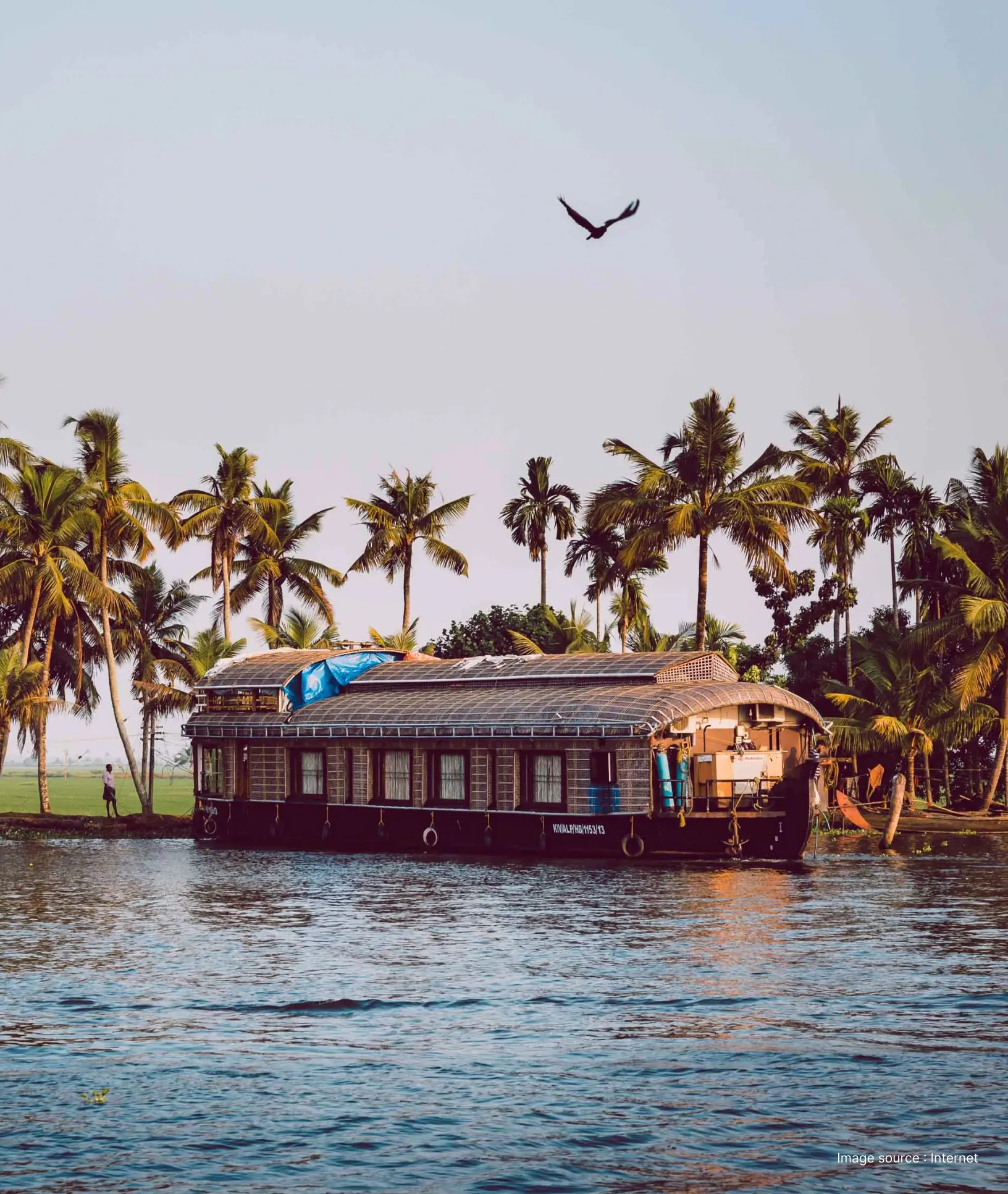 side view of a traditional houseboat vessel cruising alleppey's backwaters