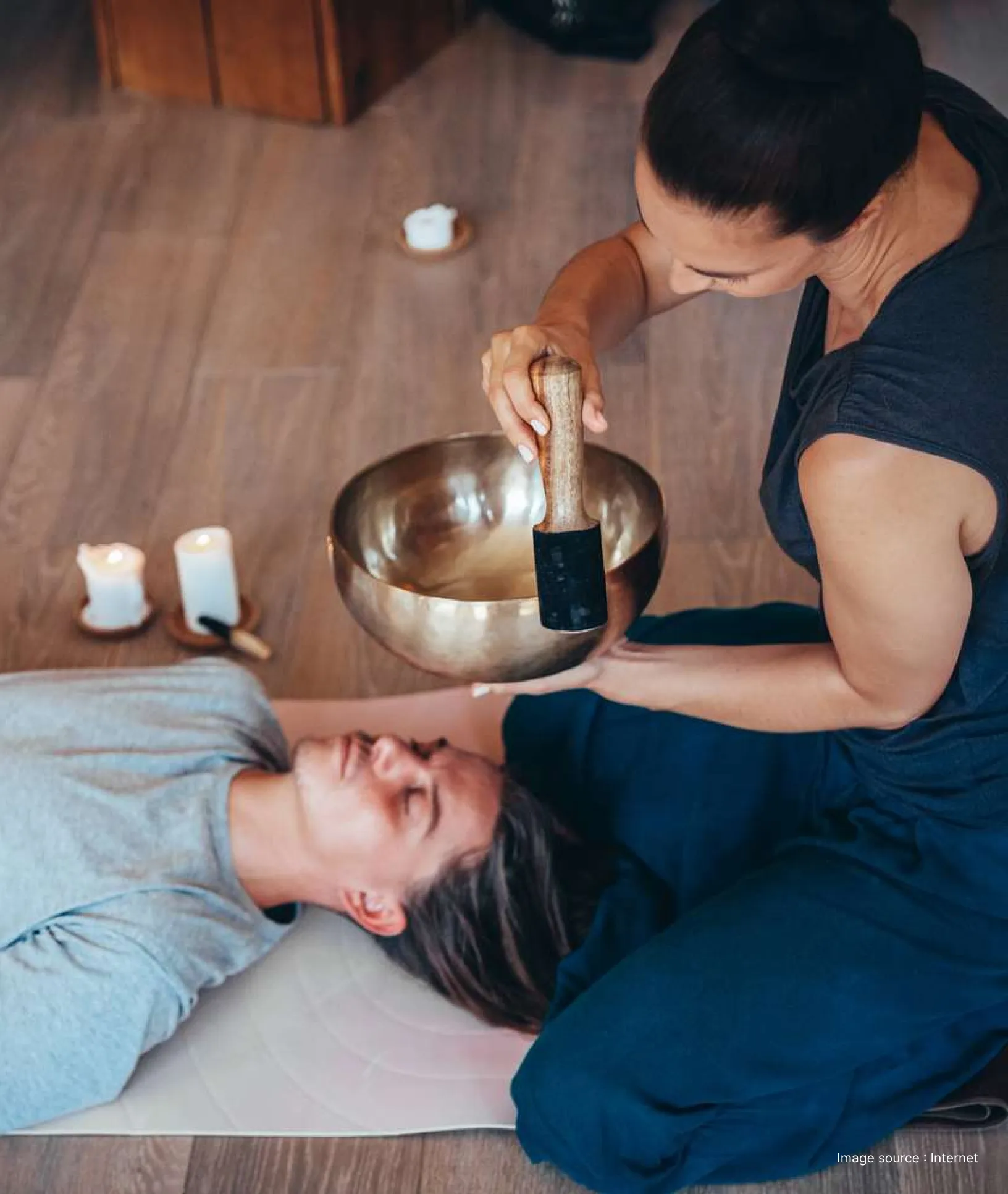 a man uses a golden bowl for sound therapy over a clients head