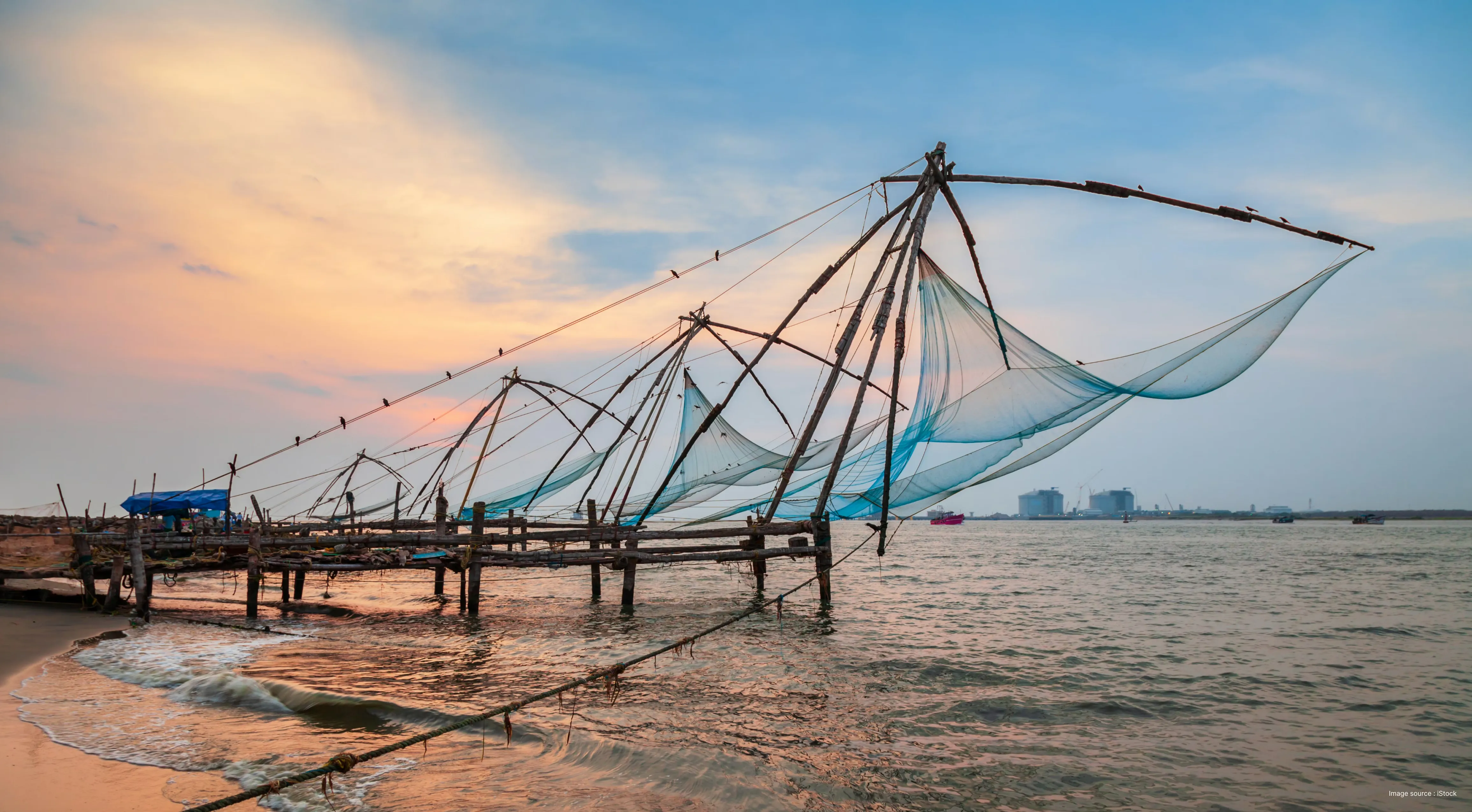 "Chinese fishing nets (Cheenavala) at sunset along the coast of Fort Kochi, Kerala"