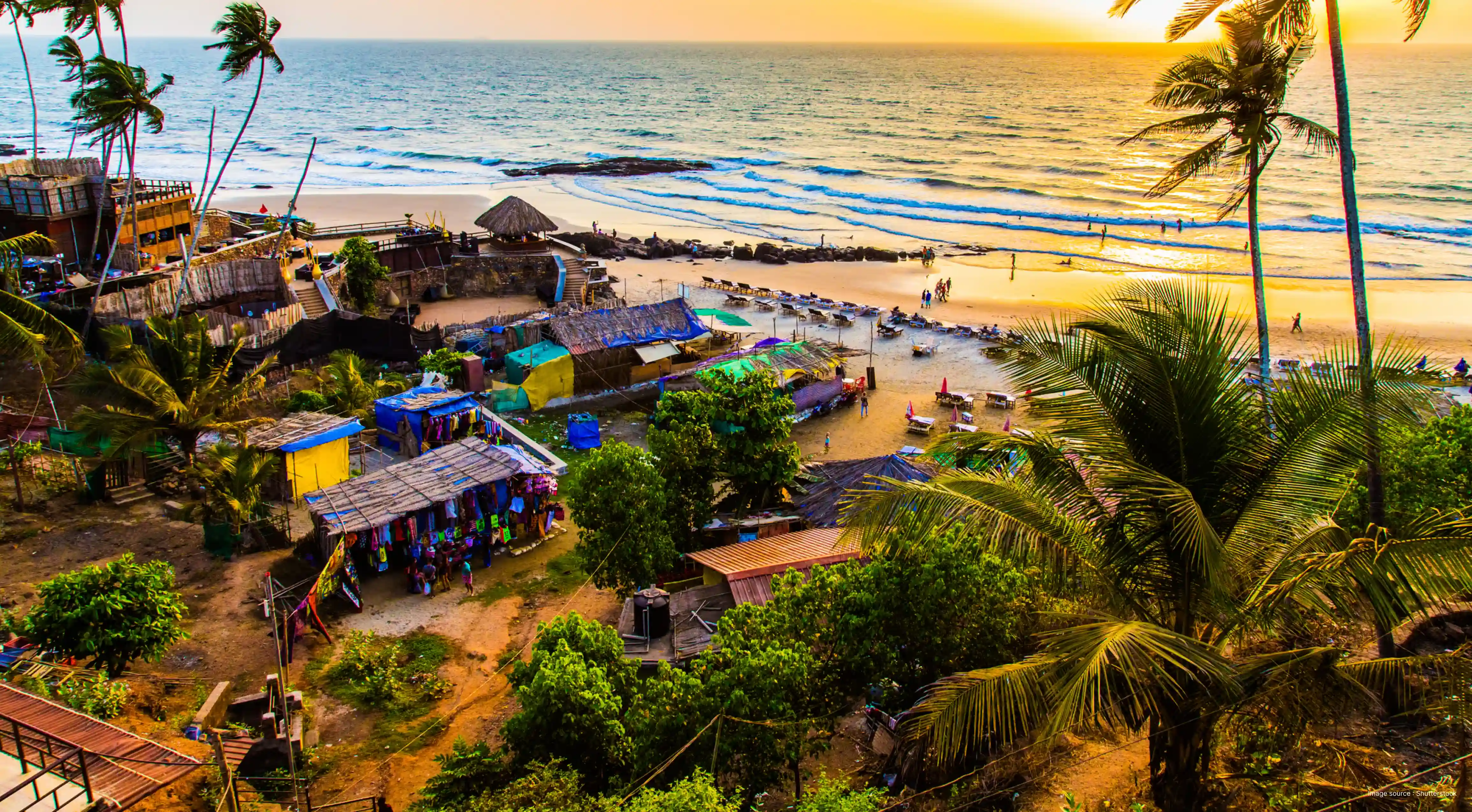 Margao Beach in Goa at sunset featuring palm-lined shoreline, beach shacks, and waves along the Arabian Sea