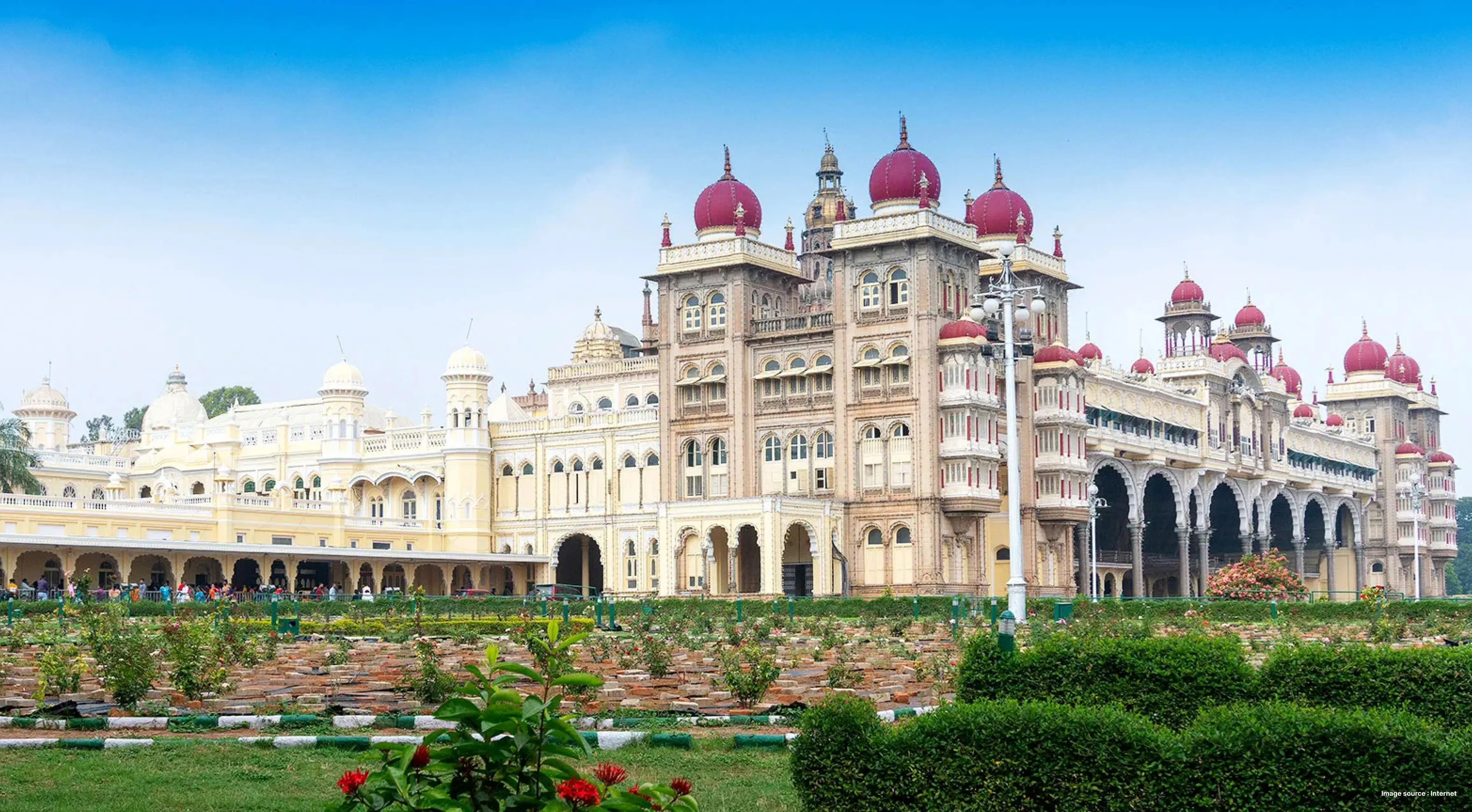 the indo saracenic architecture of mysore palace with red domes and its gardens visible in the front