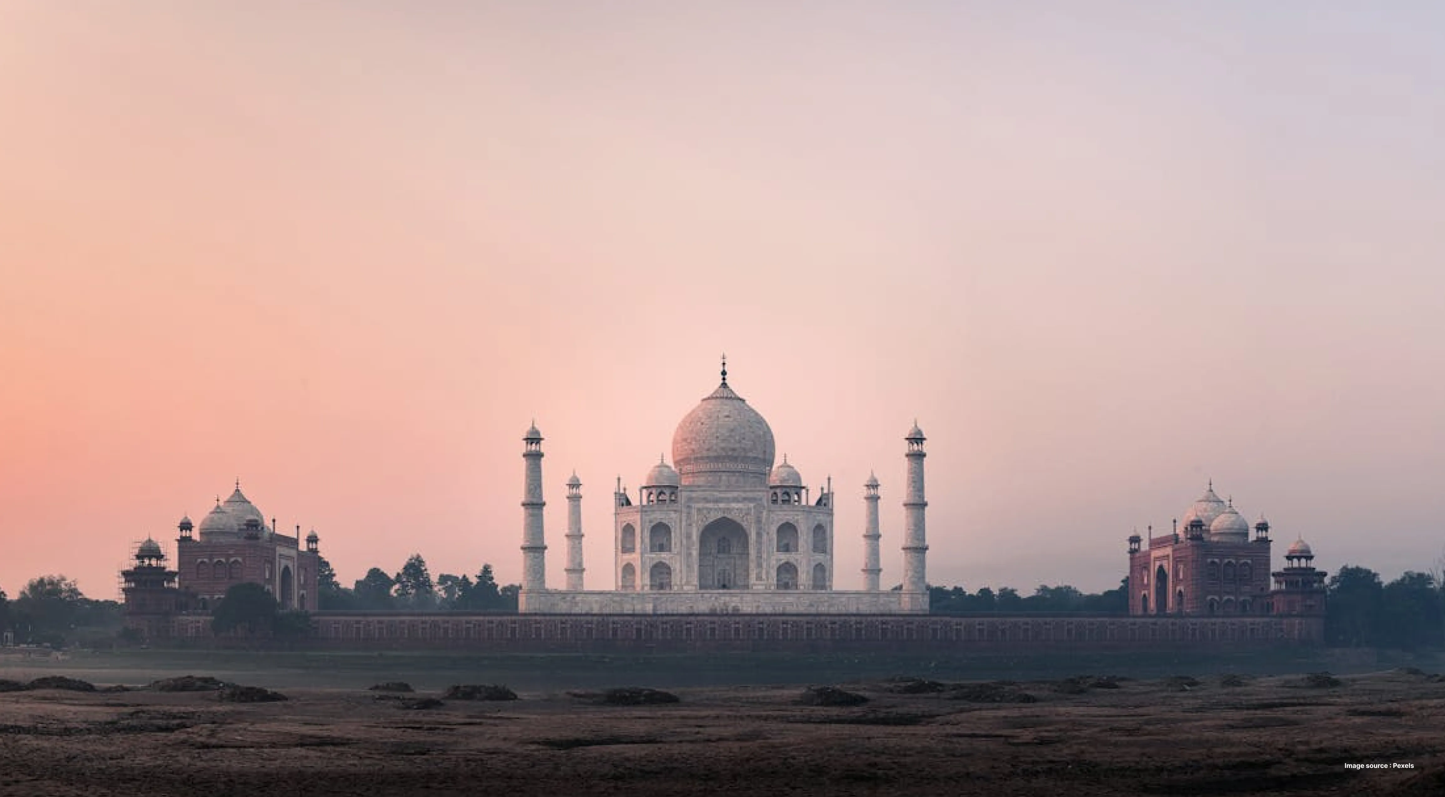 sunset view of the taj mahal with its two red sandstone gates on either side