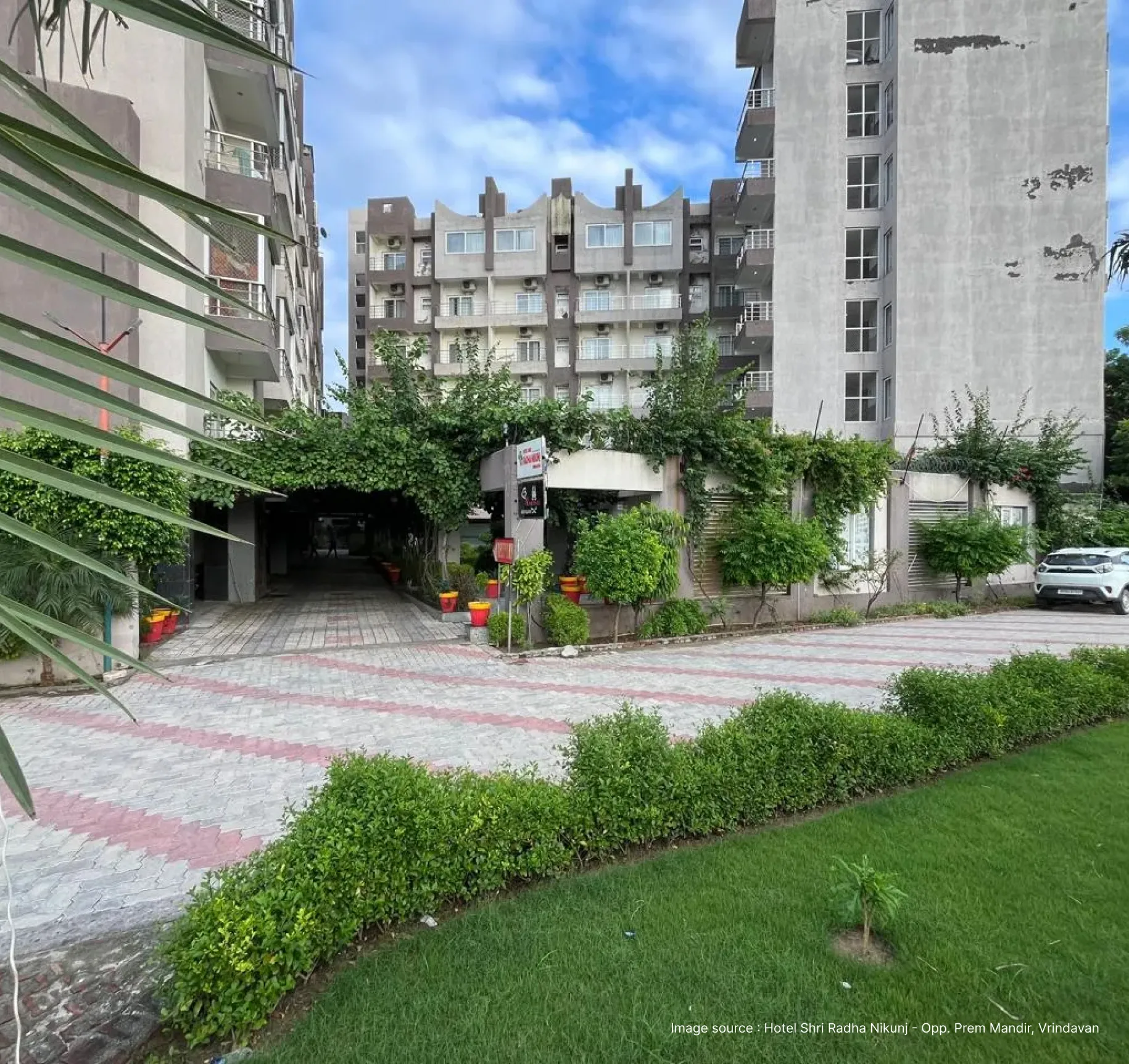 garden view and walkway of the shri radha kunj hotel in vrindvan
