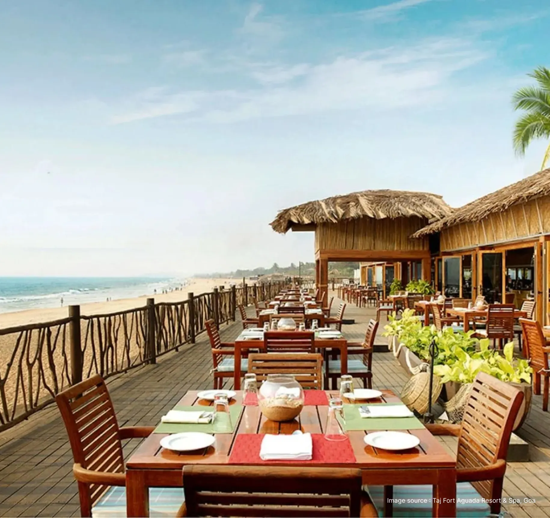 dining with wooden furniture with a view of the shore at taj fort aguada