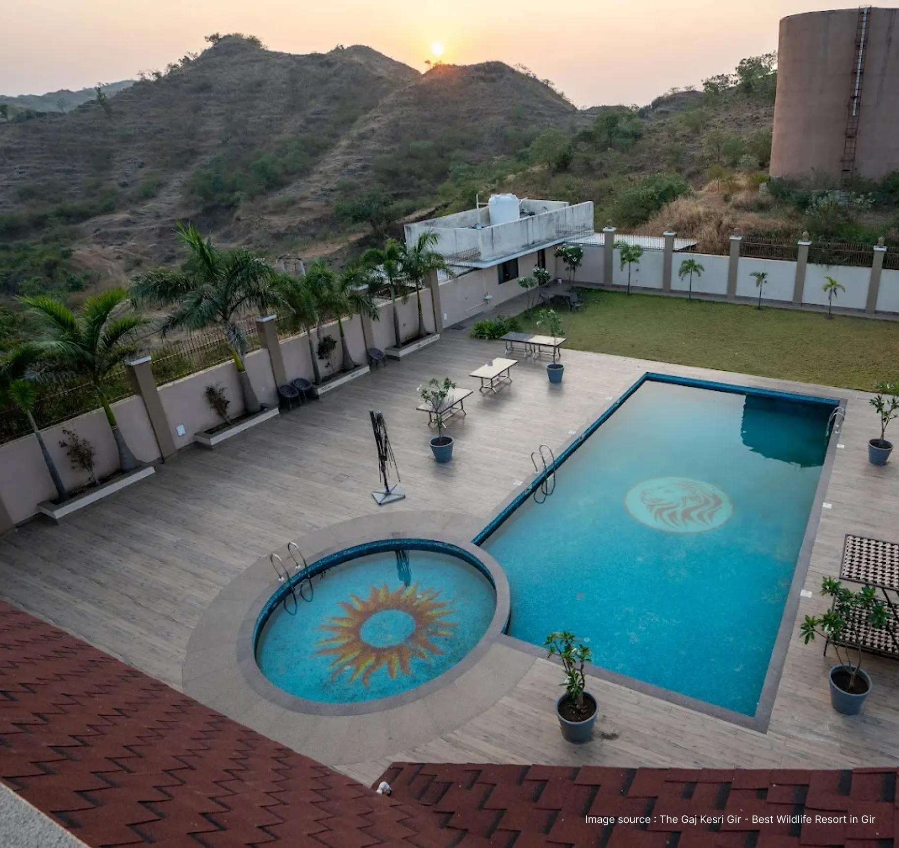 serene pool view of the the gaj gir resort with small hills in the backdrop at sunrise