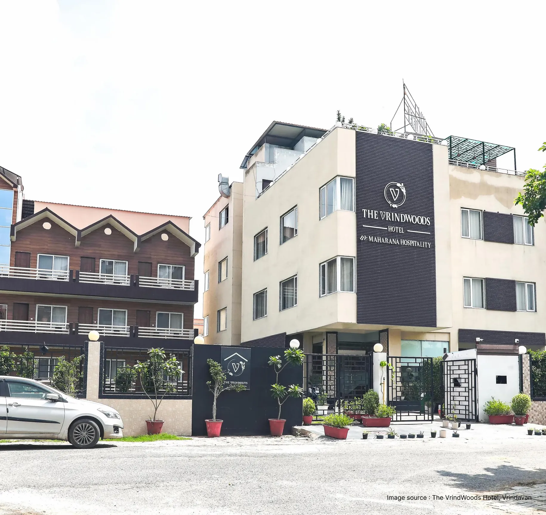 entrance with a cab standing outside the vrindwoods hotel