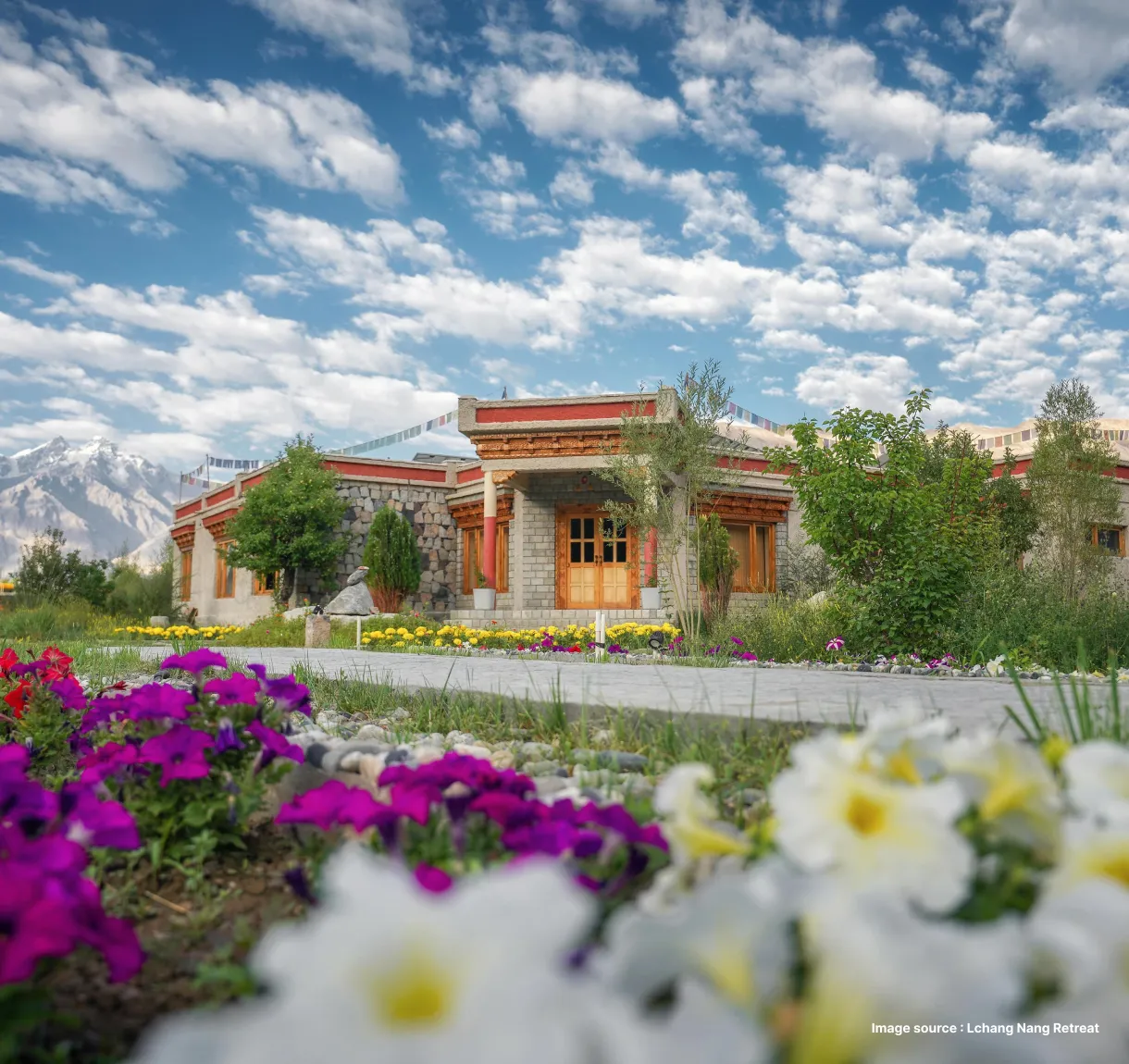 a unique angled shot of the orange building of the lchang nang retreat with a colorful flowerbed