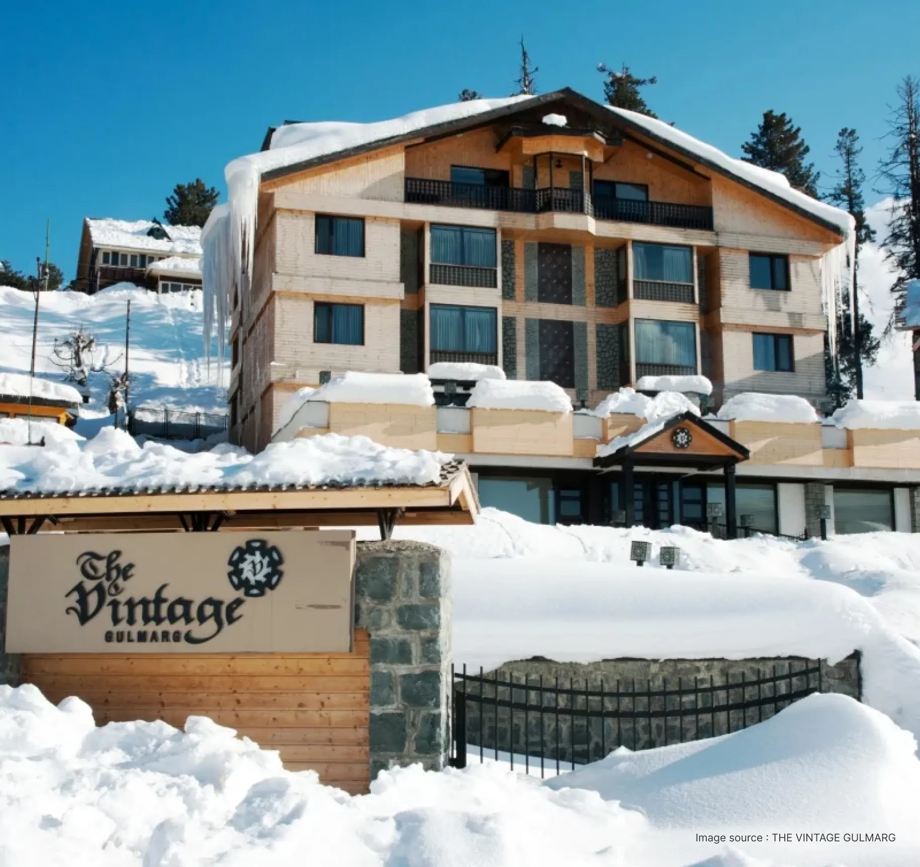 beige slant roofed hotel in snow covered gulmarg valley
