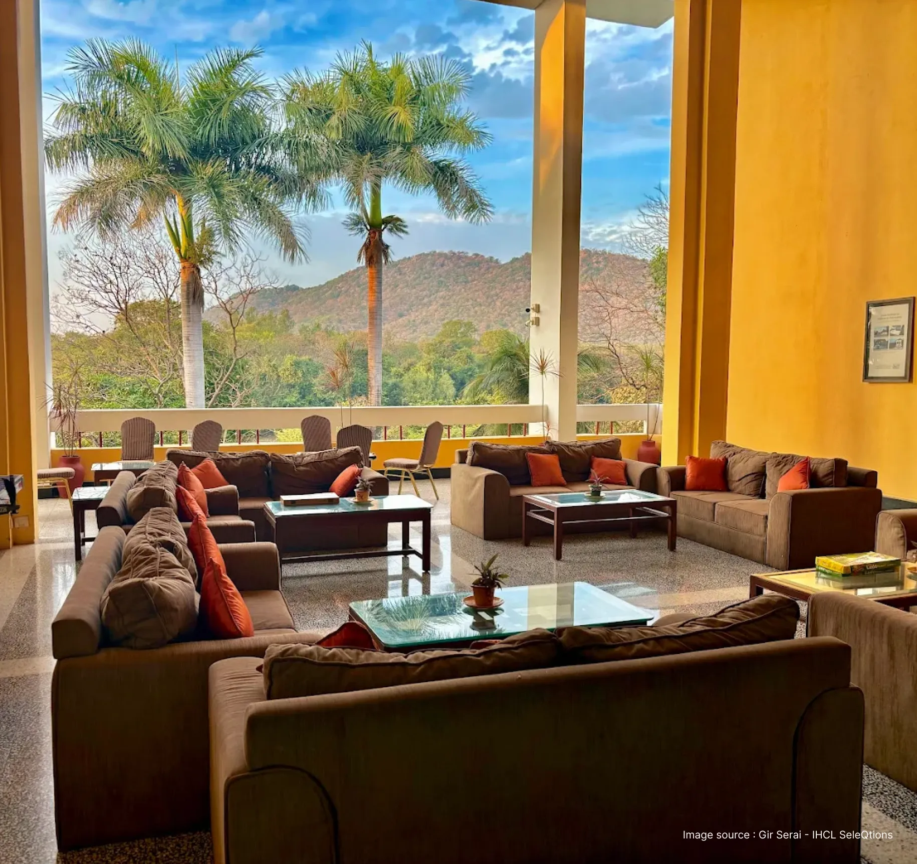 lounge with sofas in gir serai resort with view of trees and small hills