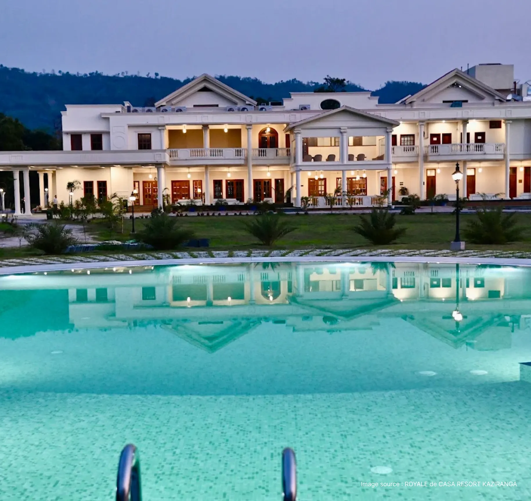 modern white architecture of the royale de casa lit up at dusk with pool view