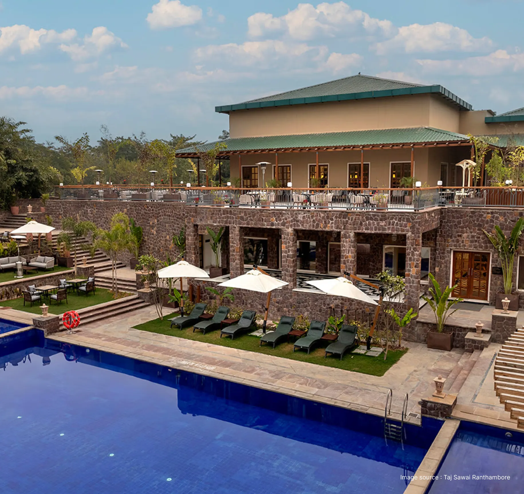 poolside view of the rugged looking taj sawai resort with restaurant area