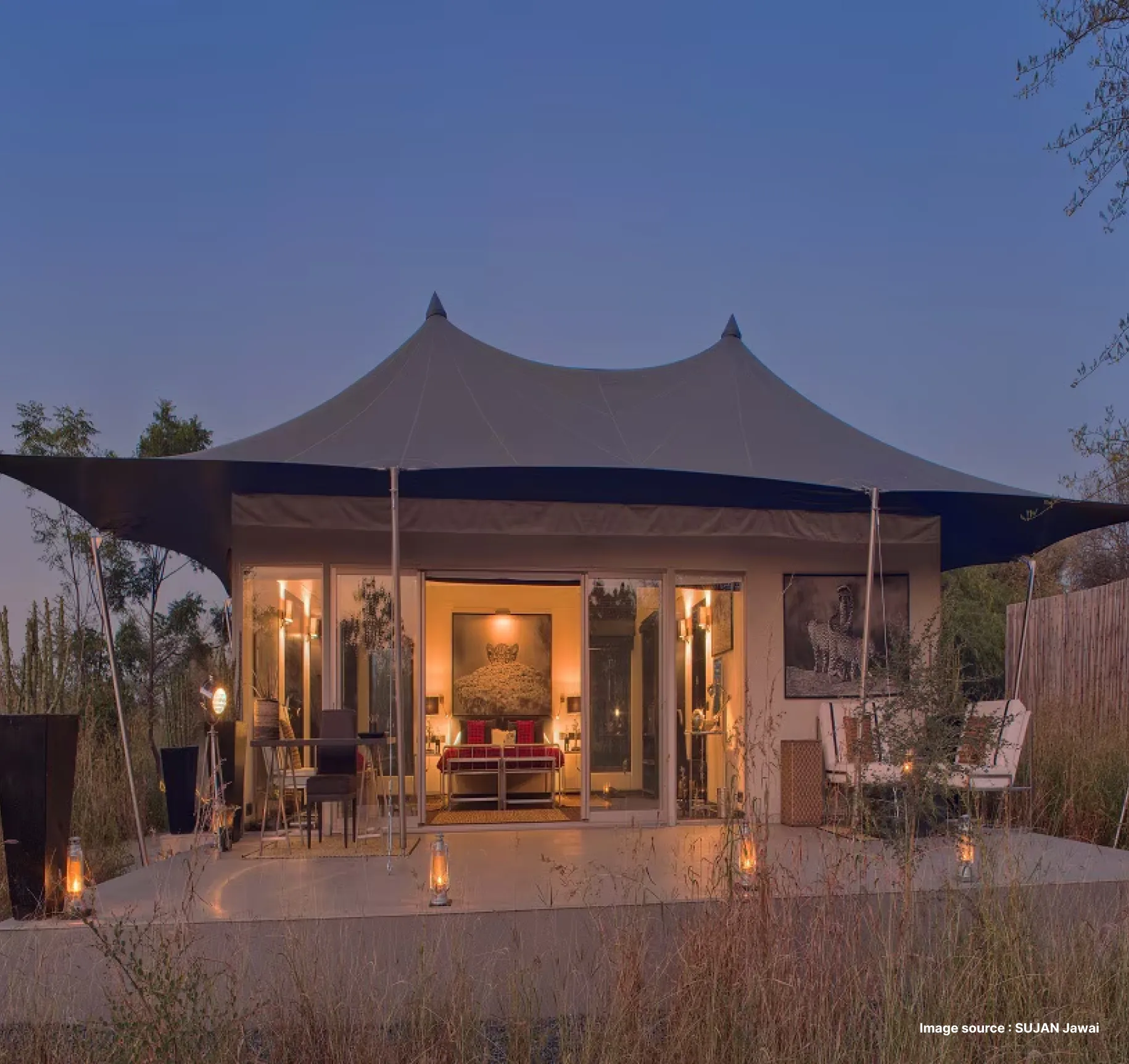 dusk time view of the lit up premier tent suite of the sujan jawai resort