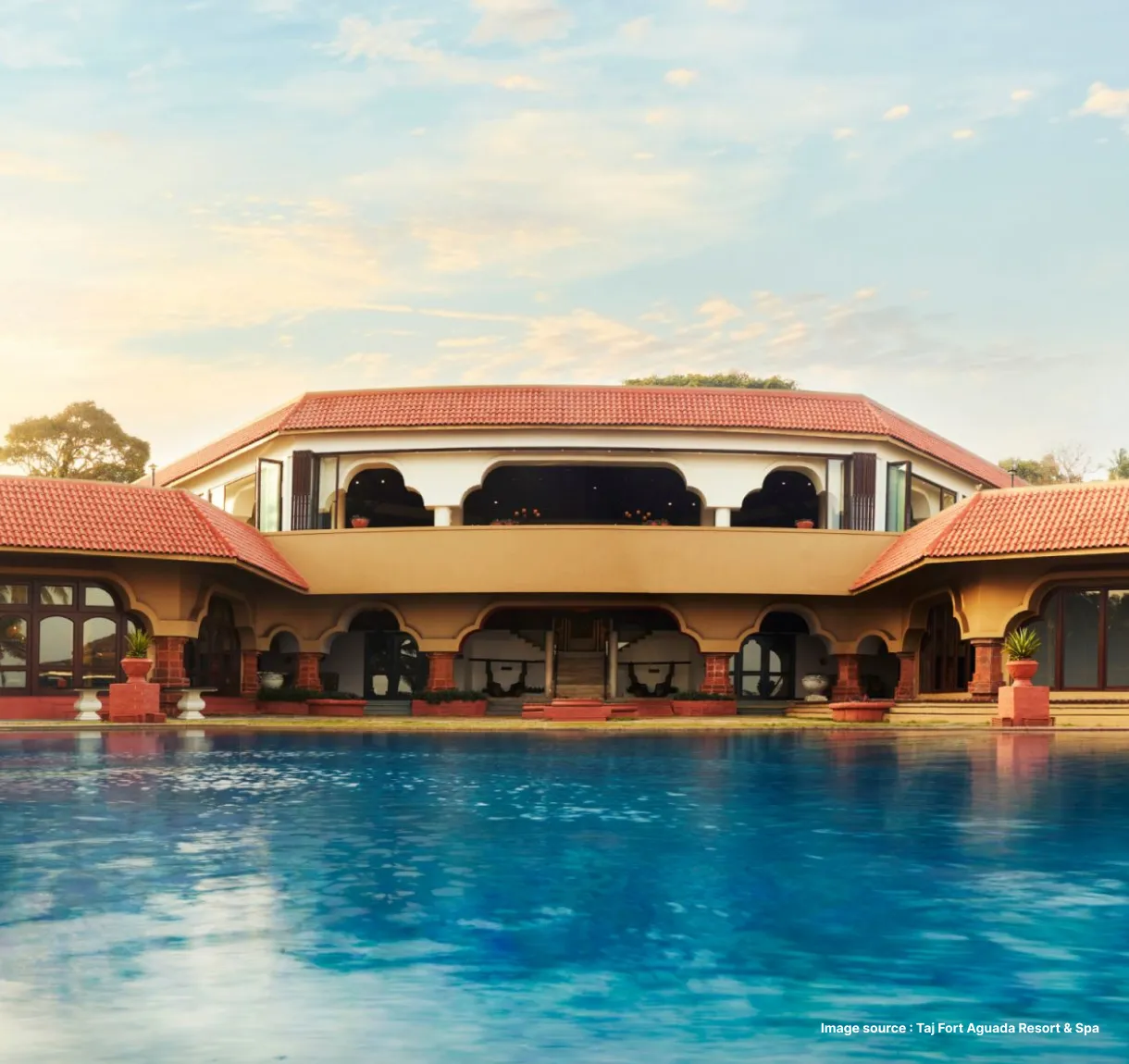 poolside view of the taj fort aguada resort with red tiled roofs