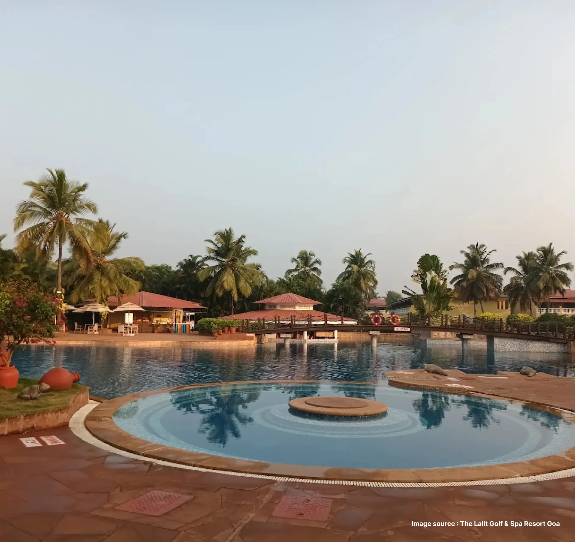 poolside of the lalit with palm trees and a spacious lounge