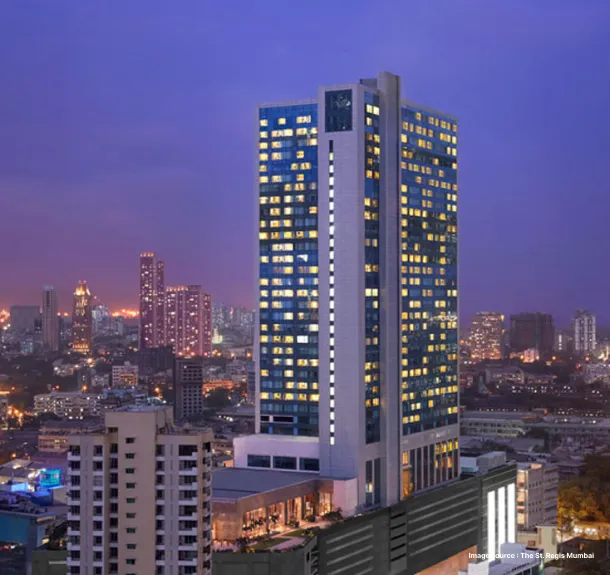 A hotel in the evening against a purple sky with its lights on