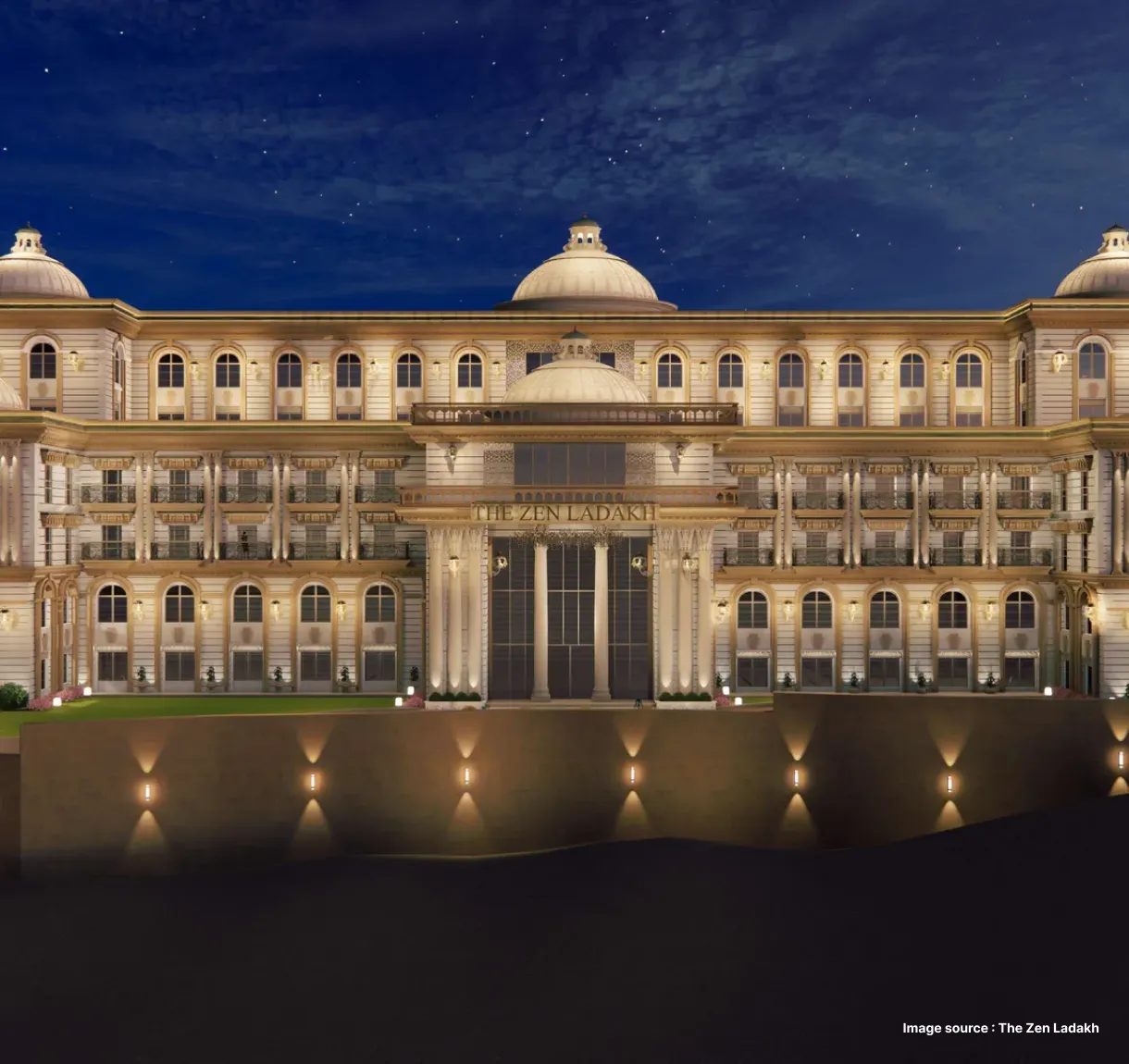 a lit up regal looking hotel entrance in ladakh at night time