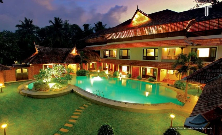 View of private villa in luxury ayurveda kerala retreat packages on the backdrop with greenery and peaceful gardens.