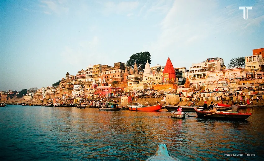 A couple practices sunrise yoga on a private terrace overlooking the Ganges, mats aligned toward the river as orange hues reflect off the water in Varanasi tour packages. 